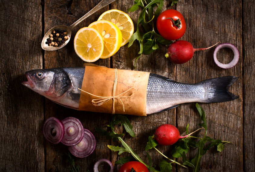 Raw Bass Fish With Vegetables From Above On The Wooden Background